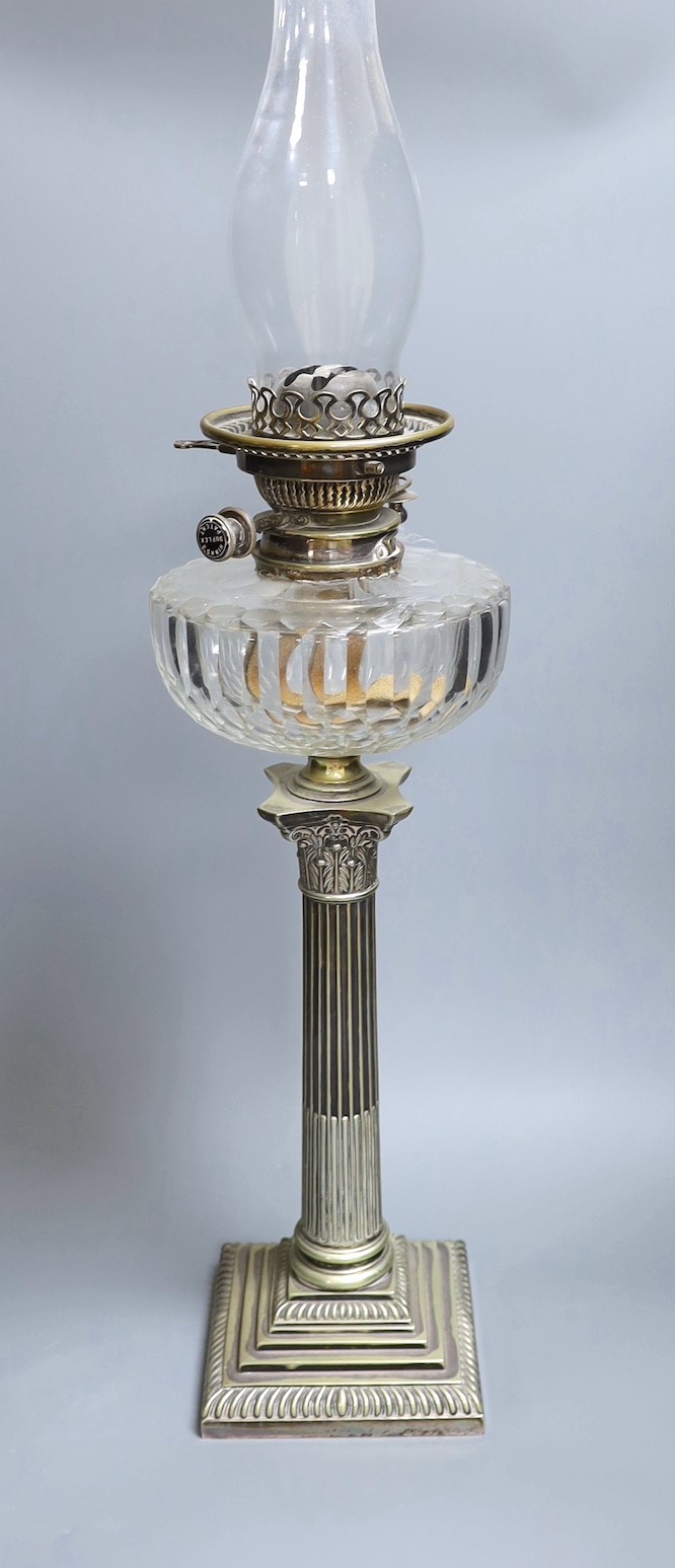 A Victorian silver plated Corinthian column oil lamp, with a glass reservoir